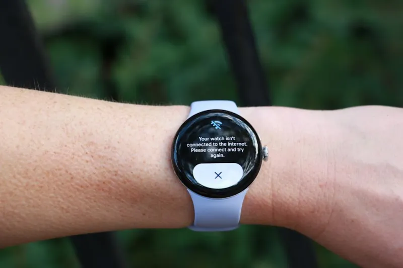 Pixel Watch 4 на запястье, поднятом в воздухе, на экране логотип Gemini.